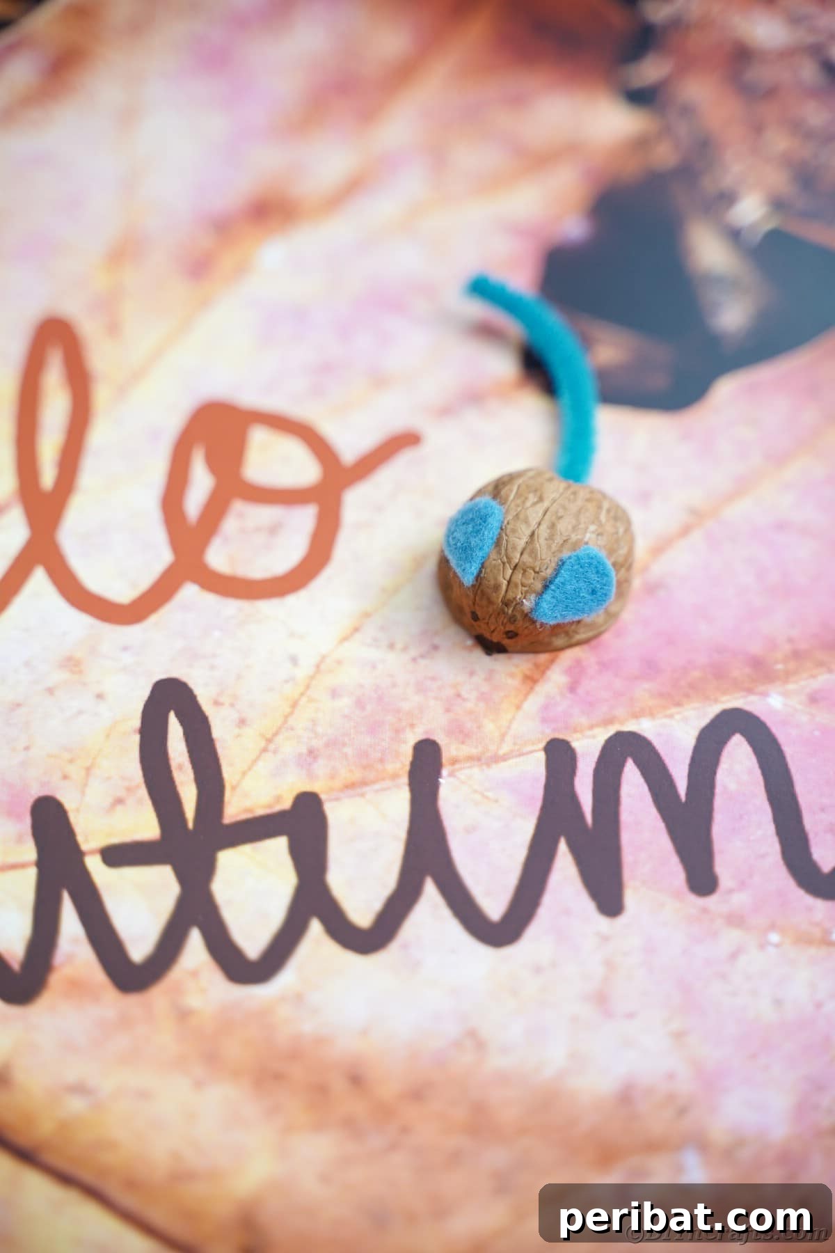 Walnut Wonders: Upcycled Shell Mouse Art 20 Walnut shell mouse artfully placed on fall-themed scrapbook paper, emphasizing its rustic charm and seasonal appeal.