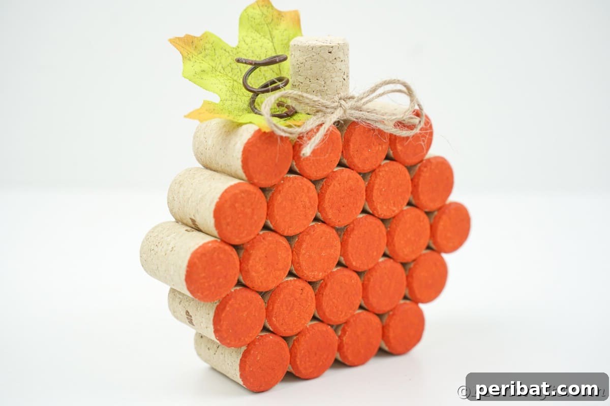 Charming Rustic Wine Cork Pumpkin Creation 3 side view of a meticulously painted orange cork pumpkin resting on a pristine white table