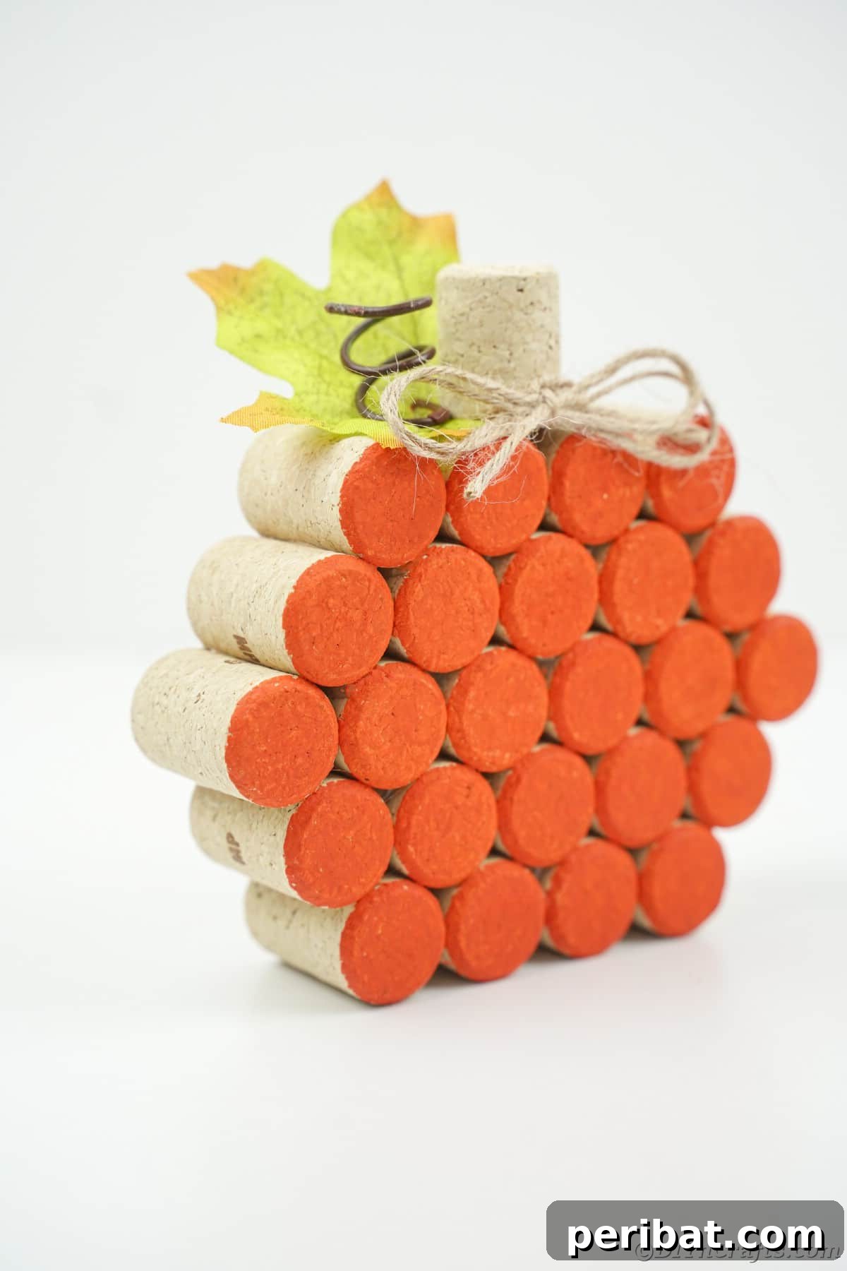 Charming Rustic Wine Cork Pumpkin Creation 23 a beautifully crafted orange pumpkin made entirely of wine corks, resting on a pristine white table