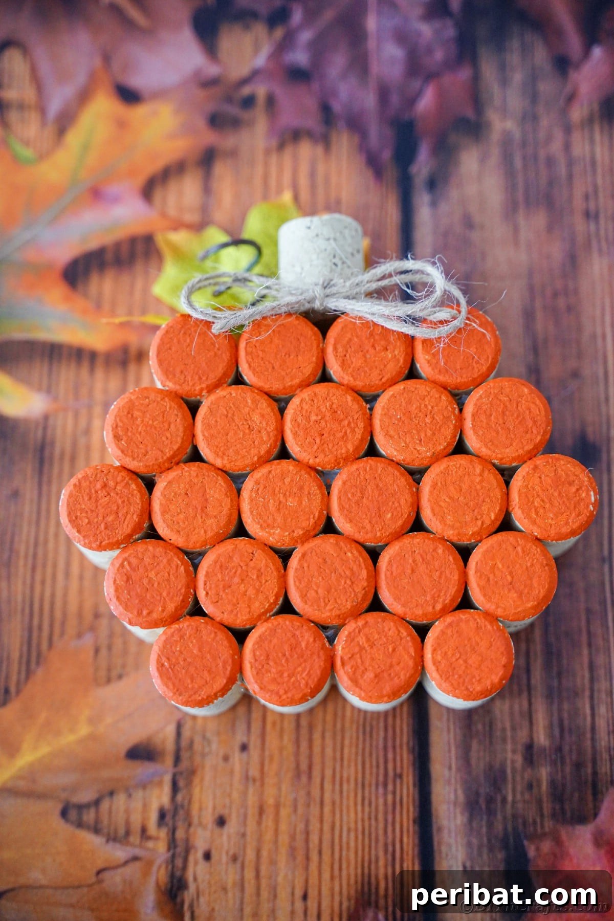 Charming Rustic Wine Cork Pumpkin Creation 4 a charming orange pumpkin crafted from wine corks sits on a table adorned with realistic fake autumn leaves