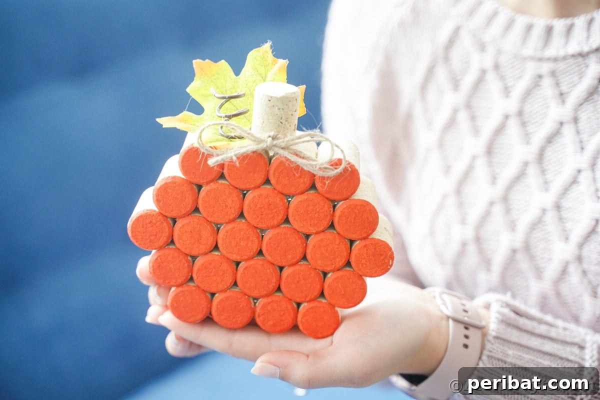 Charming Rustic Wine Cork Pumpkin Creation 7 a woman gently holding a freshly crafted wine cork pumpkin, showcasing her DIY fall decoration