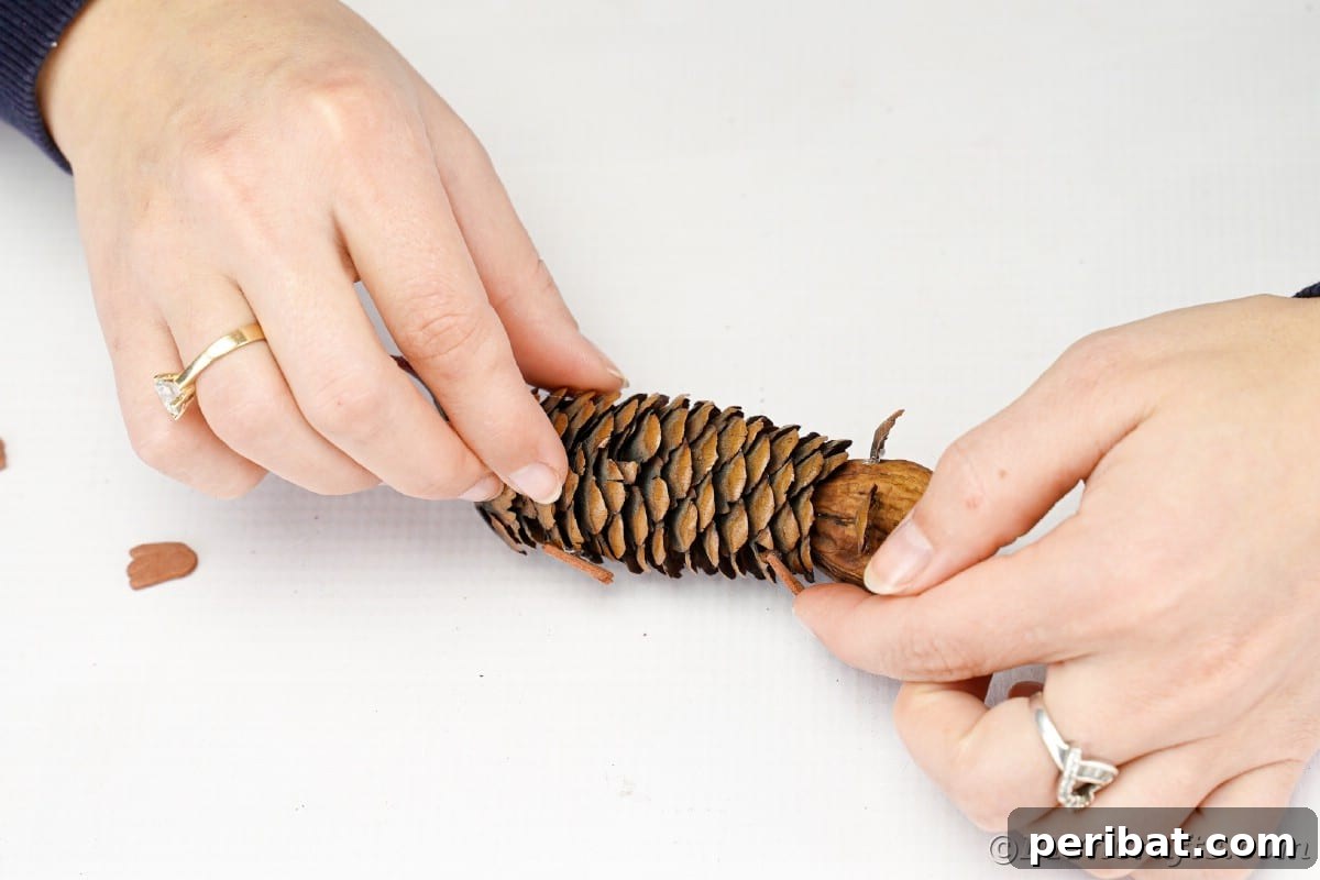 Adorable Pinecone and Pecan Mice Craft 14 Hand gluing felt ears to top of pinecone