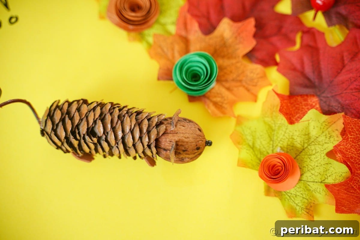 Adorable Pinecone and Pecan Mice Craft 24 pinecone mouse on yellow paper with fake leaves