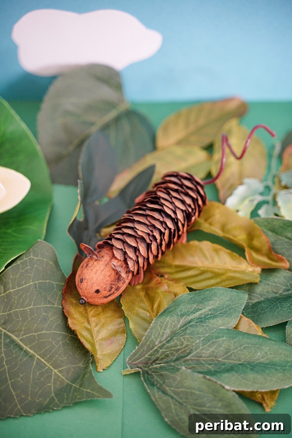 Adorable Pinecone and Pecan Mice Craft 5 pinecone mouse on fake green leaves with blue background