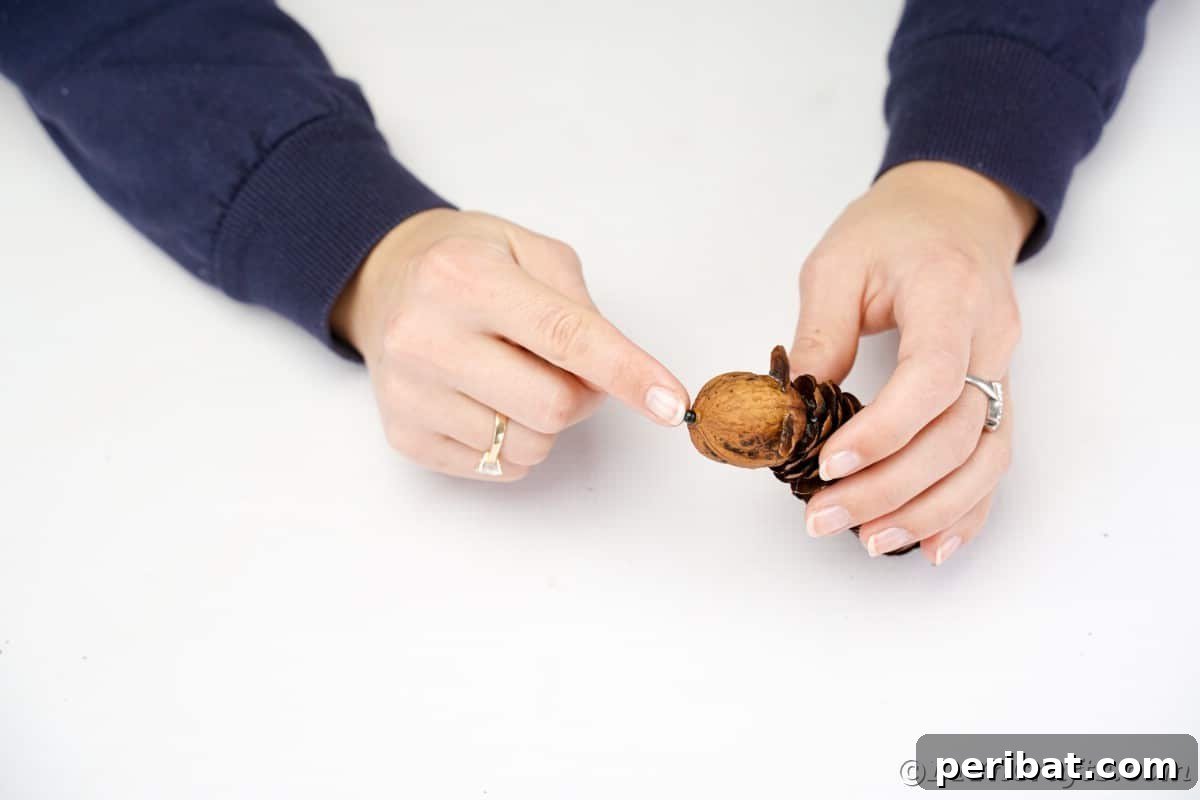 Adorable Pinecone and Pecan Mice Craft 10 gluing bead on the end of pecan on pinecone mouse