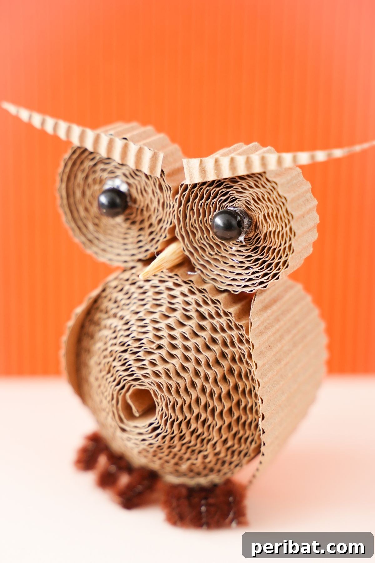 Rustic Rolled Cardboard Owl Art 4 cardboard owl with black bead eyes in front of orange background