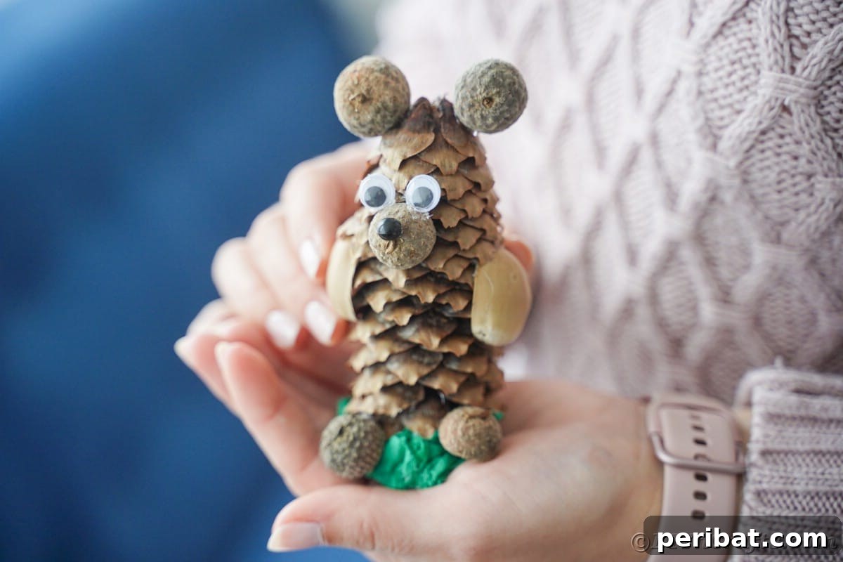 Woman holding a finished animal craft made from a pinecone