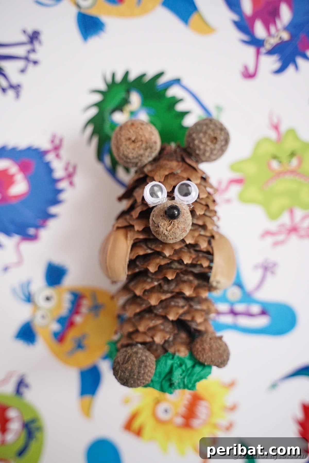 Pinecone bear sitting on monster-themed paper, showing versatility in display