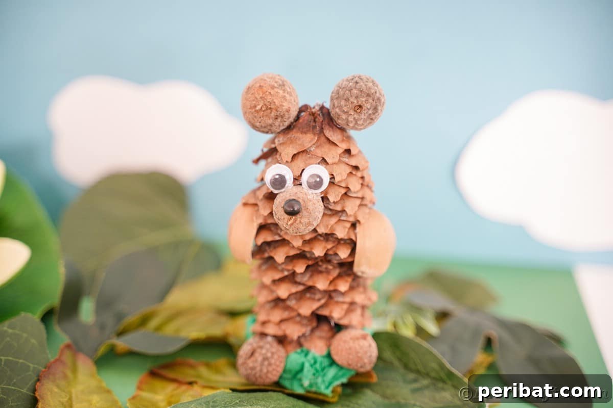 Bear craft made from a pinecone and nuts sitting on fake autumn leaves