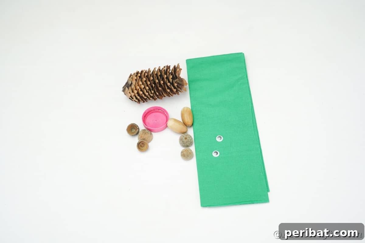 Pinecone, green tissue paper, bottle cap, and acorn caps arranged on a white table