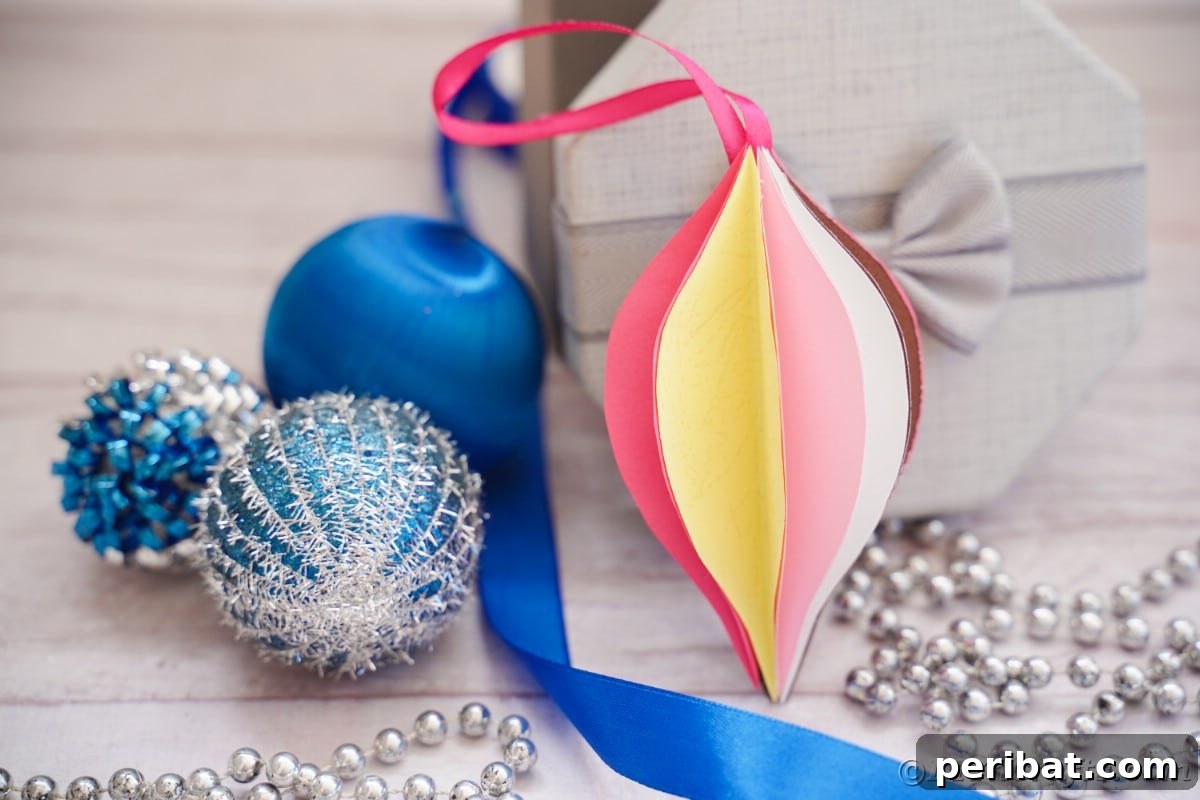 Whimsical Paper Evergreen Decor 3 Handmade paper ornament artfully displayed against a backdrop of blue ribbon and other Christmas decorations