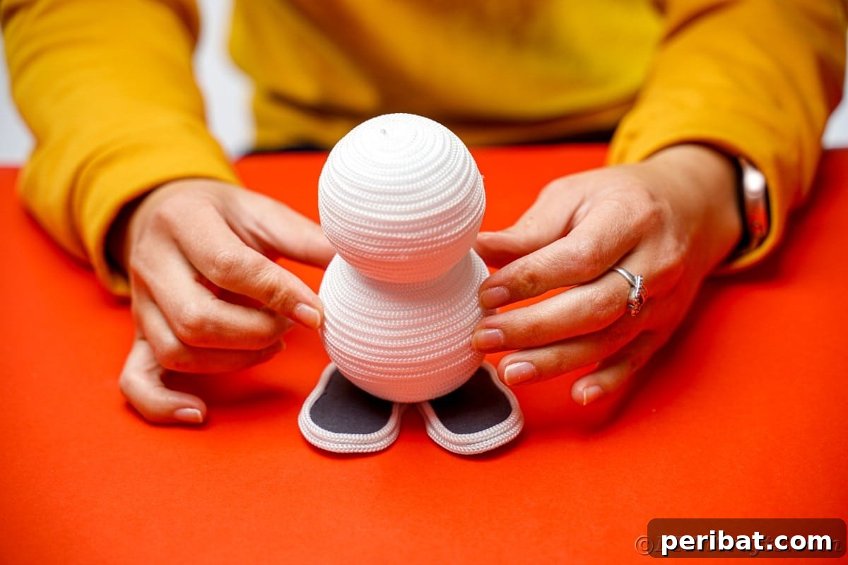 Cozy Twine Snowman Christmas Charm 16 hands holding styrofoam balls on top of two black feet