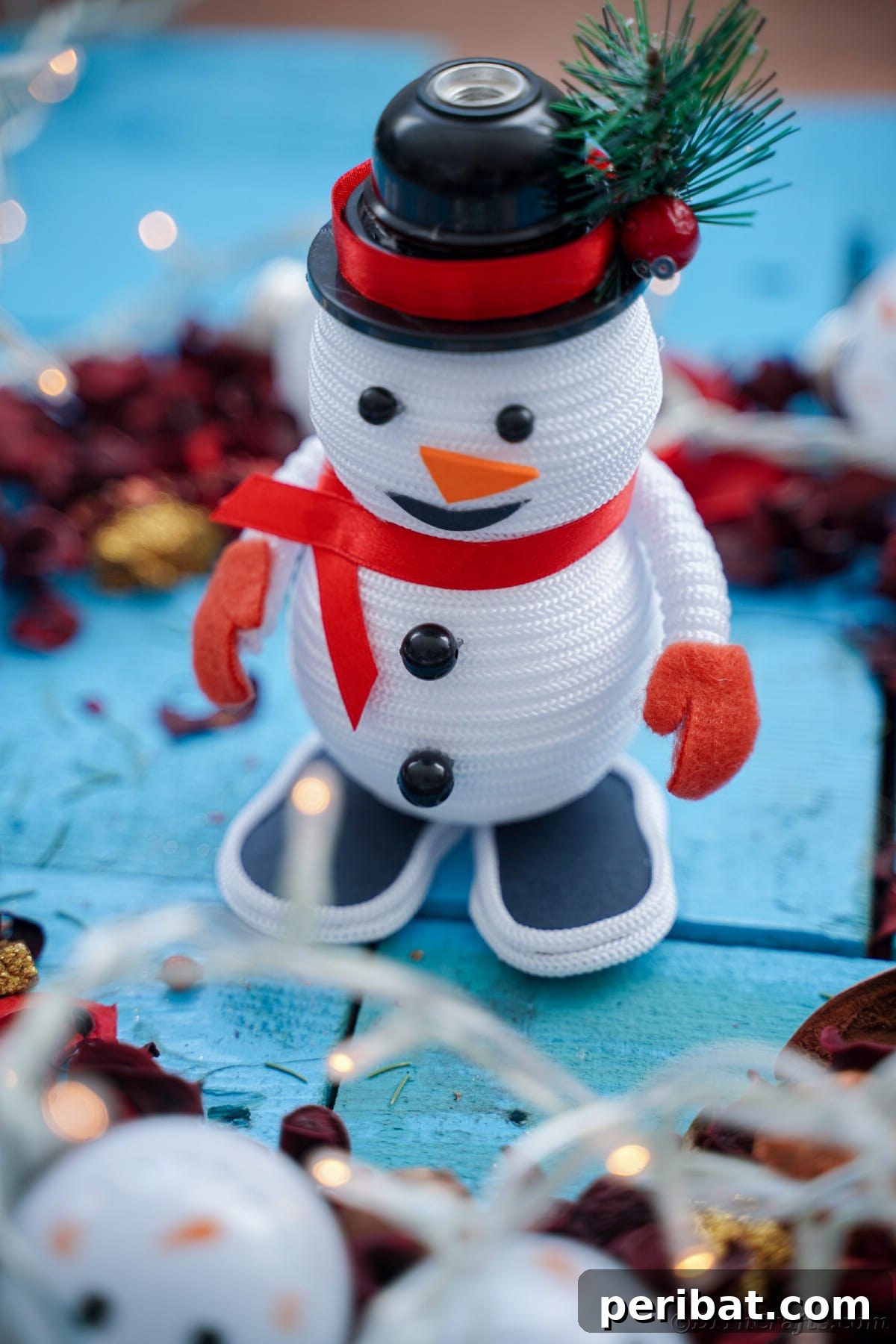 Cozy Twine Snowman Christmas Charm 27 mini snowman decoration on blue table with pinecones
