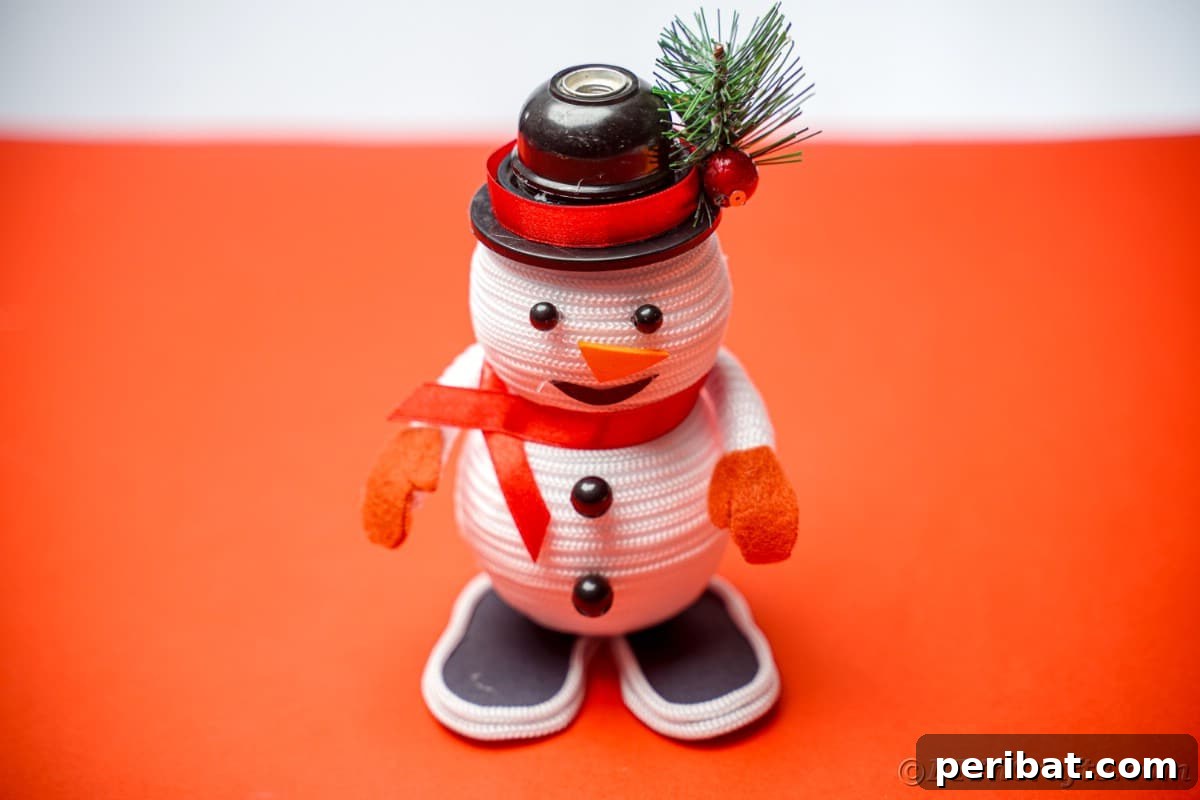 Cozy Twine Snowman Christmas Charm 7 rope snowman sitting on red table