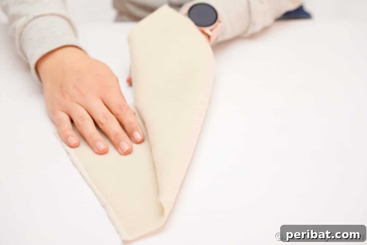 Rolling a piece of cream felt to sculpt it into the classic conical hat shape for the gnome.