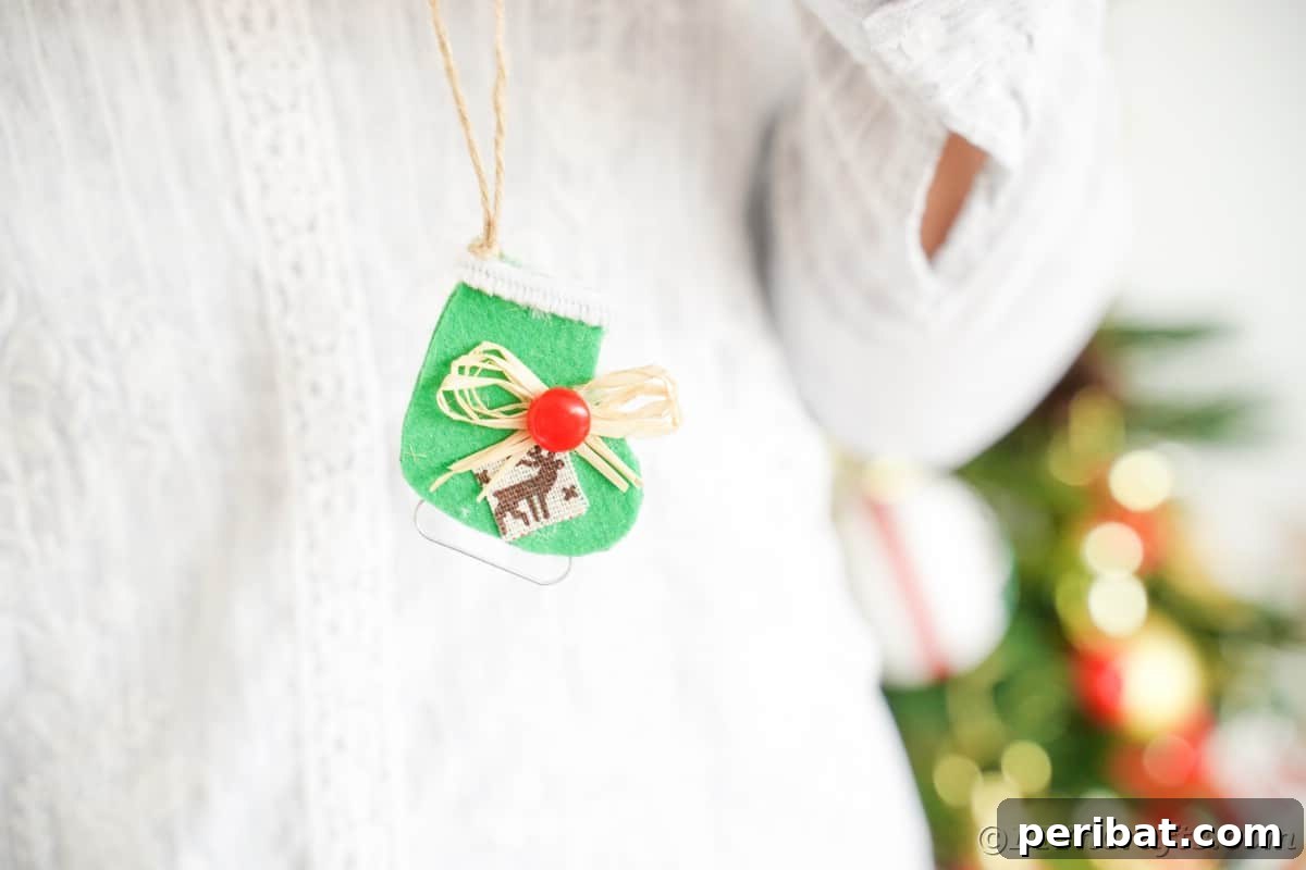 lady holding mini ice skate ornament in front of tree