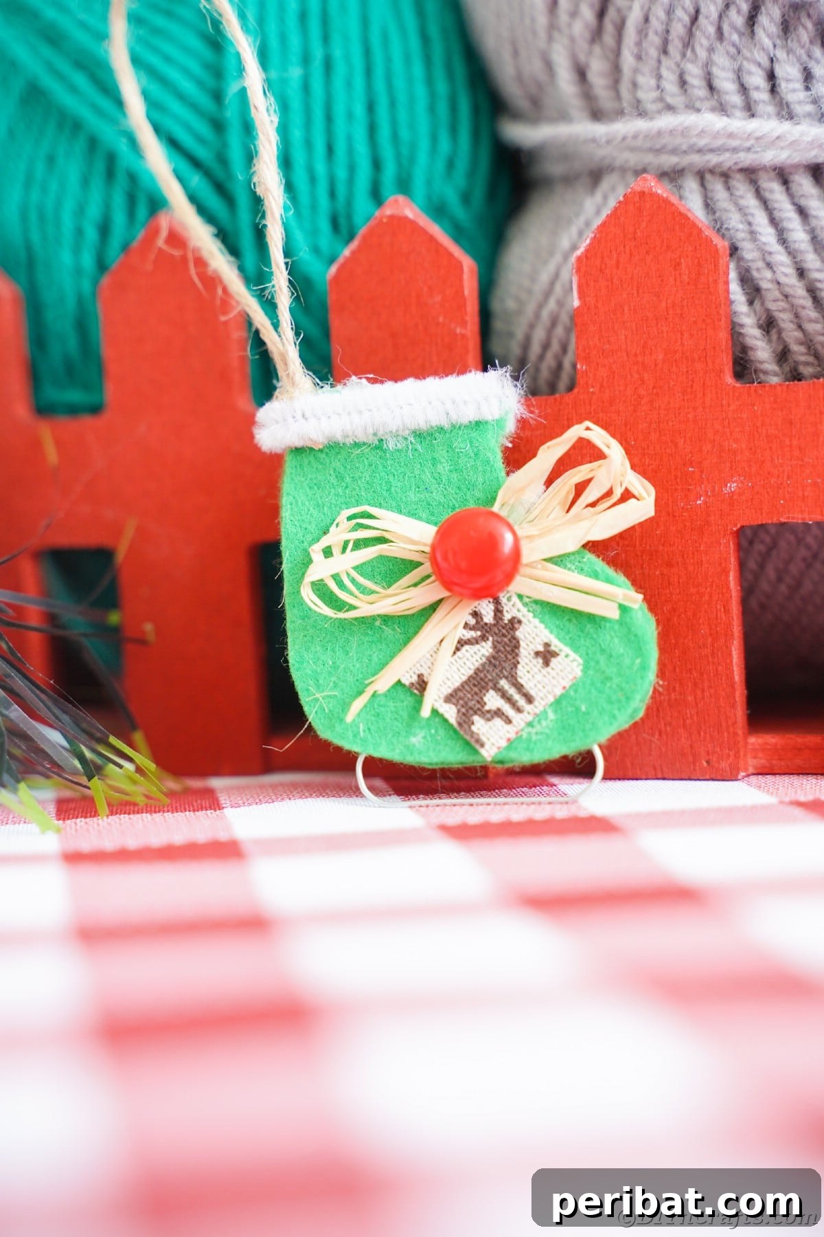 felt green ice skate hanging by fake red fence