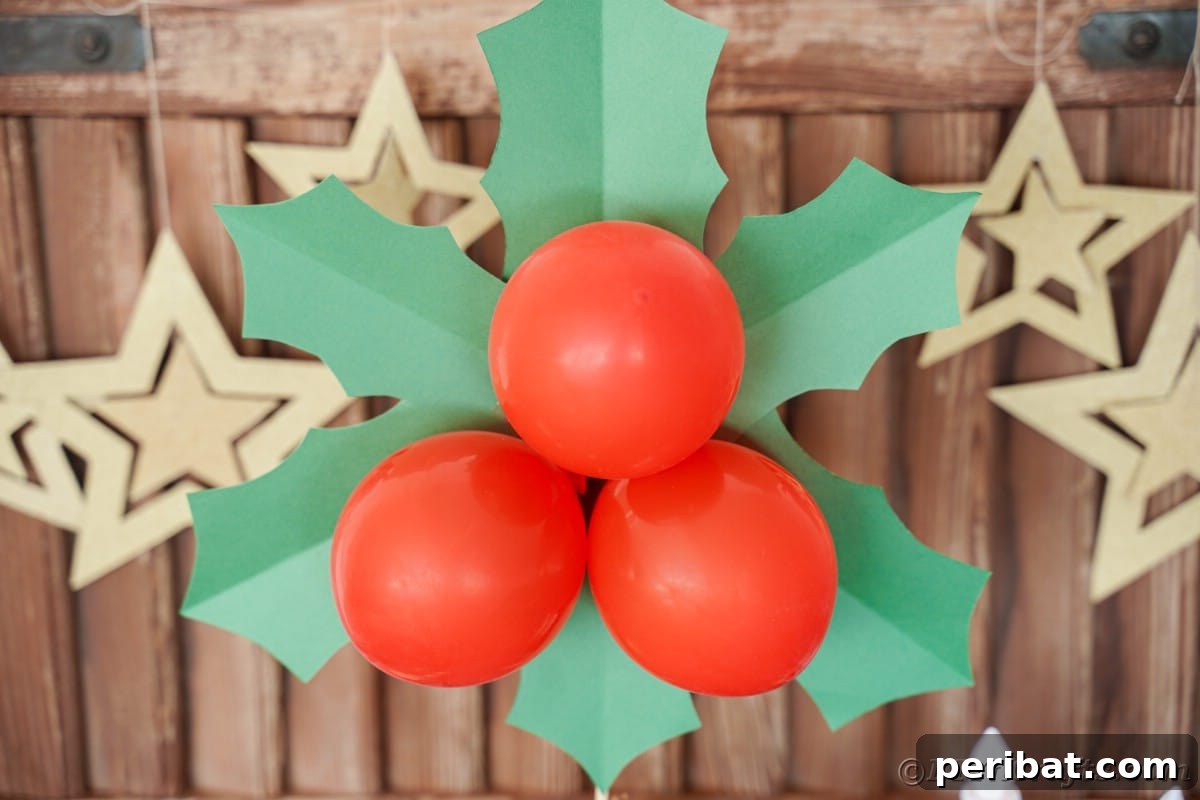 Oversized Holly Berry and Leaf Festive Decor 7 paper christmas leaves and berries in front of wood wall