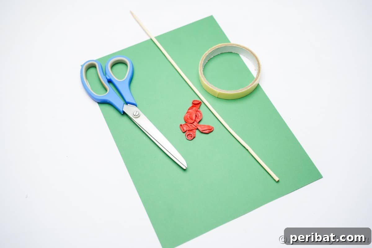 Oversized Holly Berry and Leaf Festive Decor 9 green paper red balloons scissors and a dowel on white table