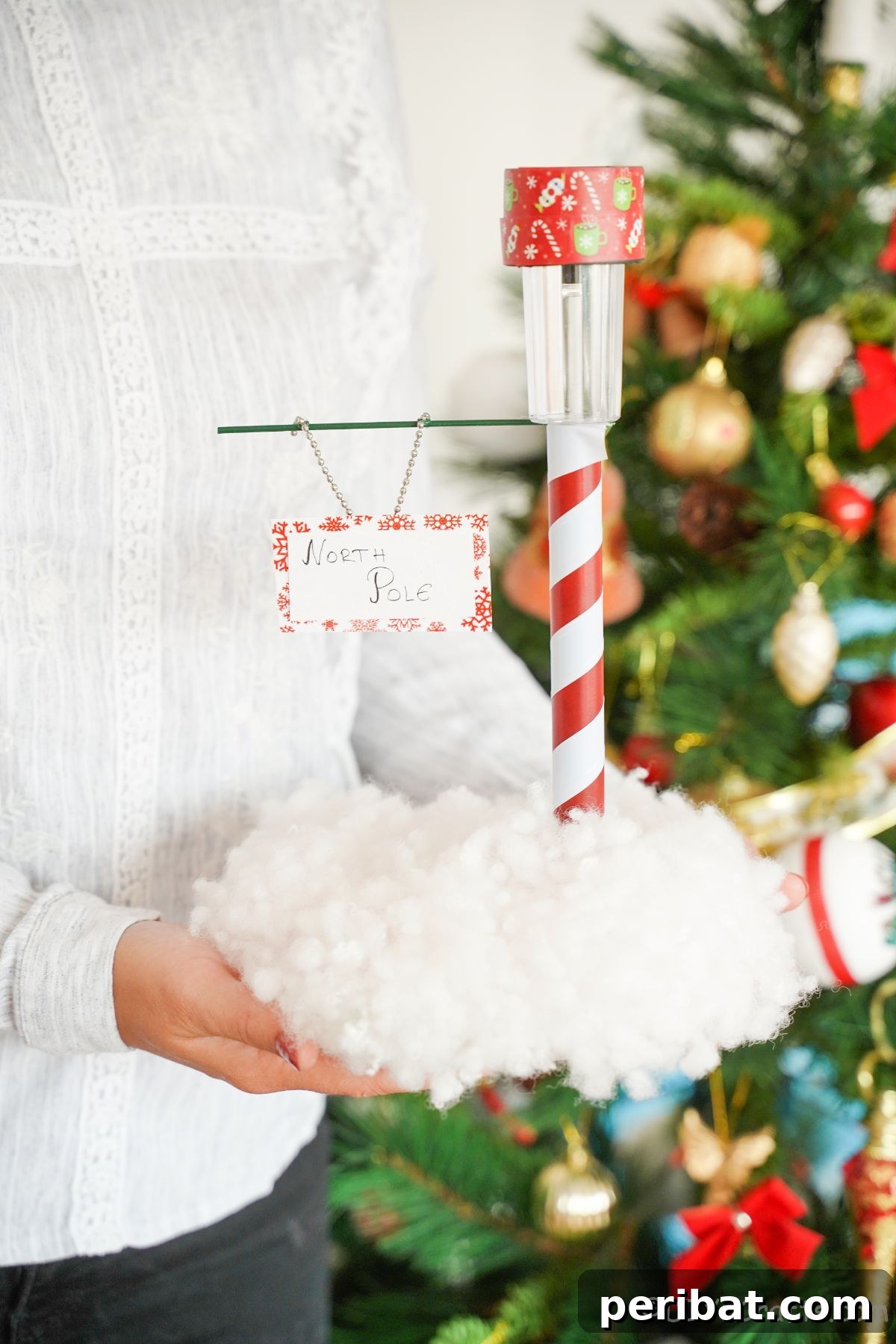 Whimsical Arctic Lamppost Craft 18 solar light sign with snow base being held by person in white sweater
