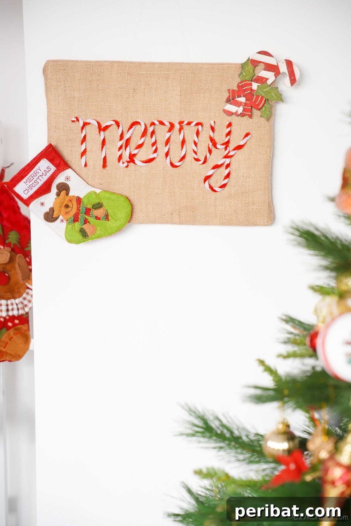 Farmhouse Burlap Christmas Decor 16 burlap sign that says merry hanging on wall by Christmas tree