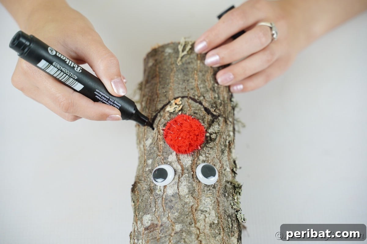 Whimsical Woodland Log Reindeer Decor 11 woman using marker to draw smile on log
