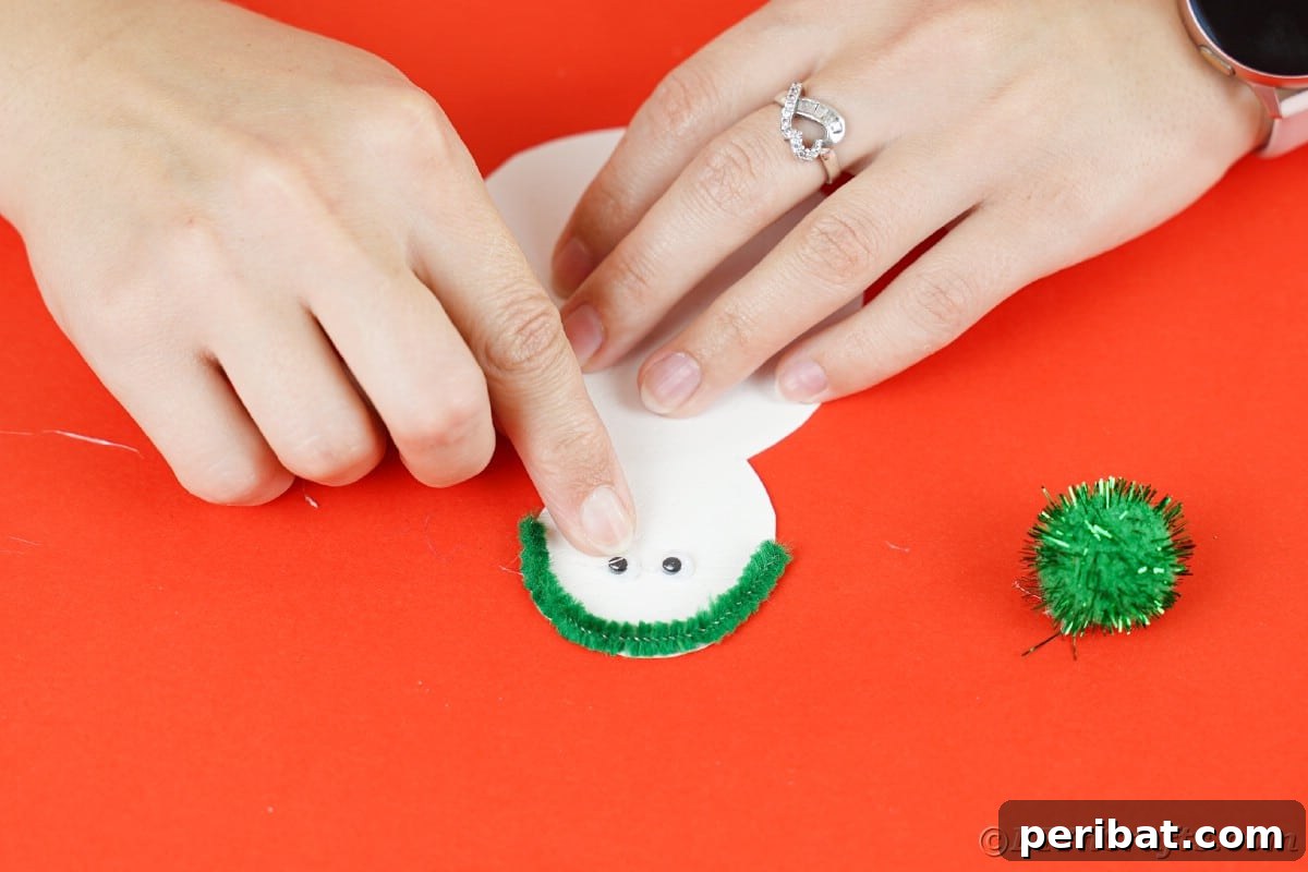 Simple Snowman Christmas Card Craft for Children 12 hand adding googly eyes to snowman