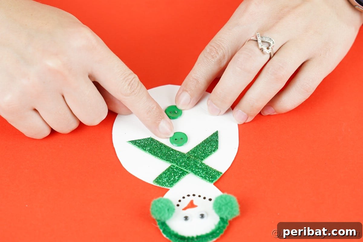 Simple Snowman Christmas Card Craft for Children 16 hand holding green button down on middle of paper snowman