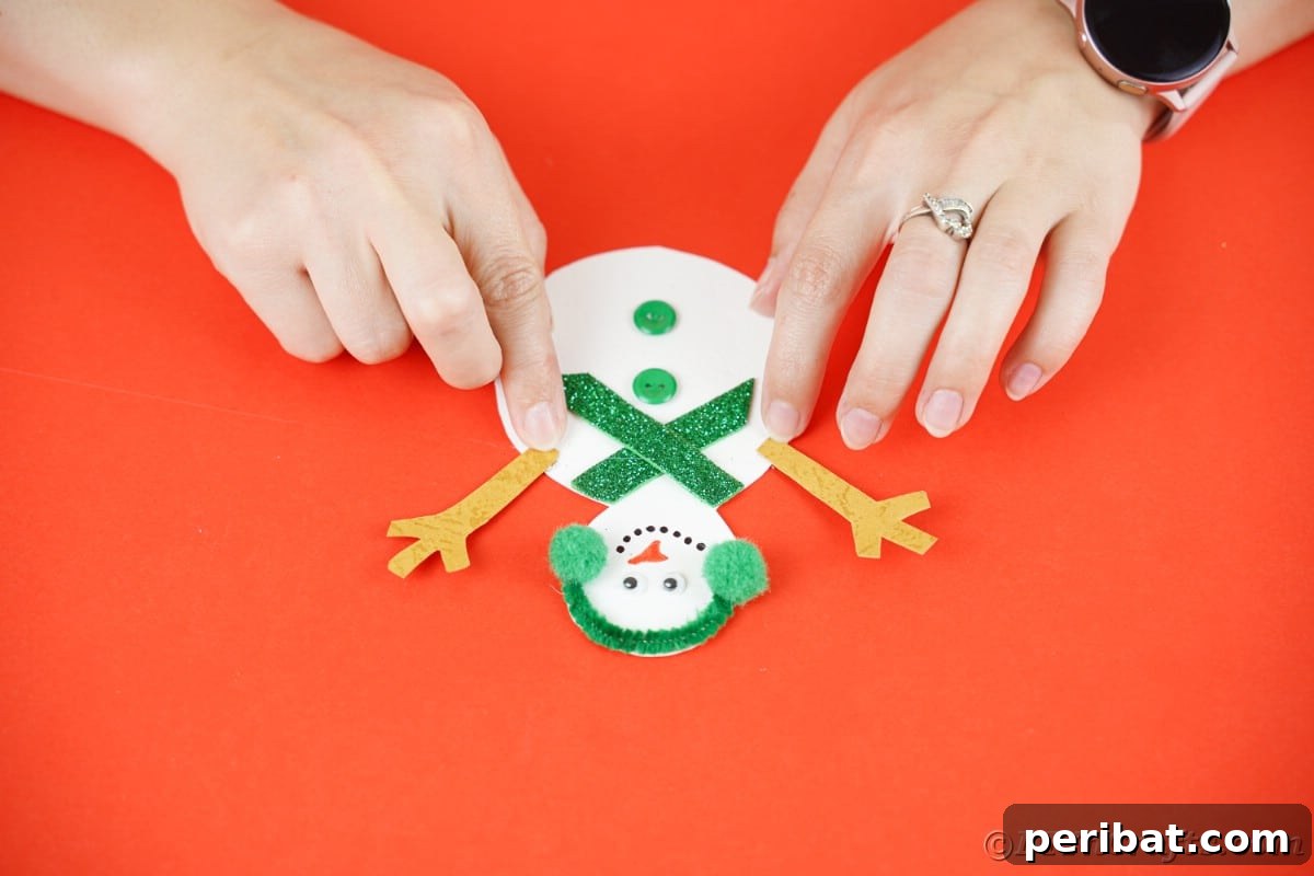 Simple Snowman Christmas Card Craft for Children 17 hands putting arms on snowman