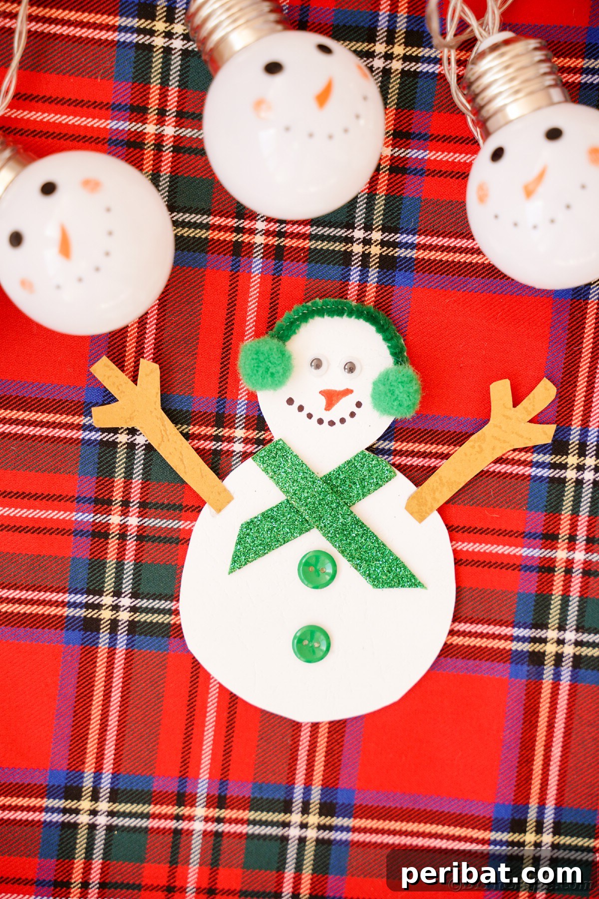 Simple Snowman Christmas Card Craft for Children 6 paper snowman on plaid surface with snowman lights