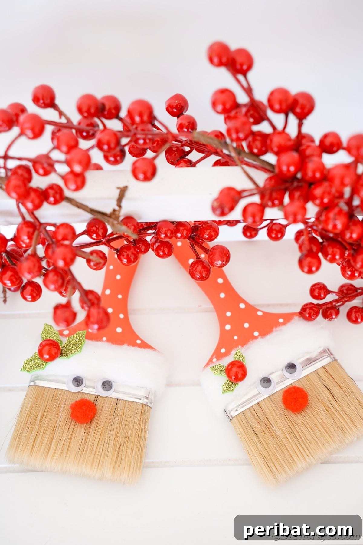 A collection of paintbrush Santas adorned with holly berries, beautifully arranged on a table, ready for the festive season.