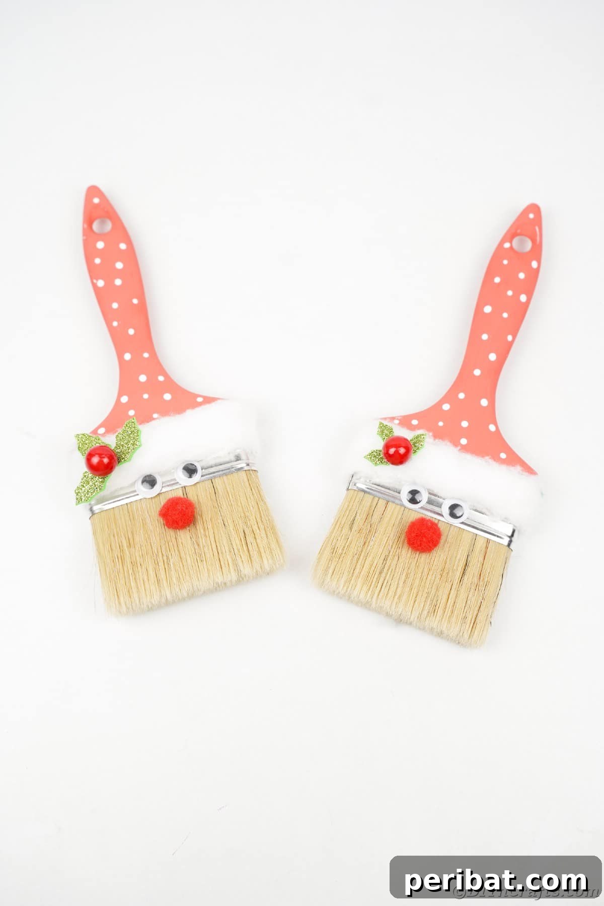 A display of cheerful red and white paintbrush Santa Claus decorations arranged on a pristine white table, highlighting their clean, festive look.