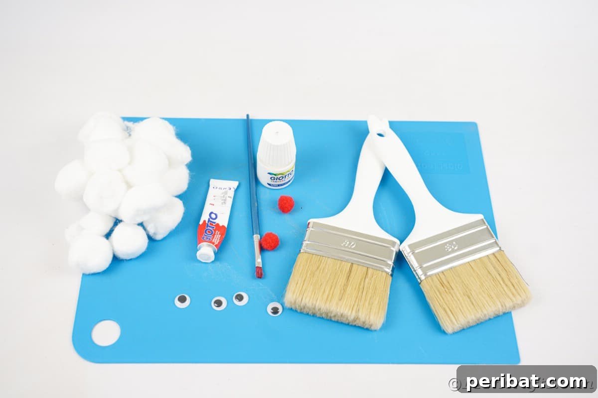 Crafting supplies including paintbrushes, paints, and cotton balls neatly arranged on blue paper, ready for the Santa Claus project.
