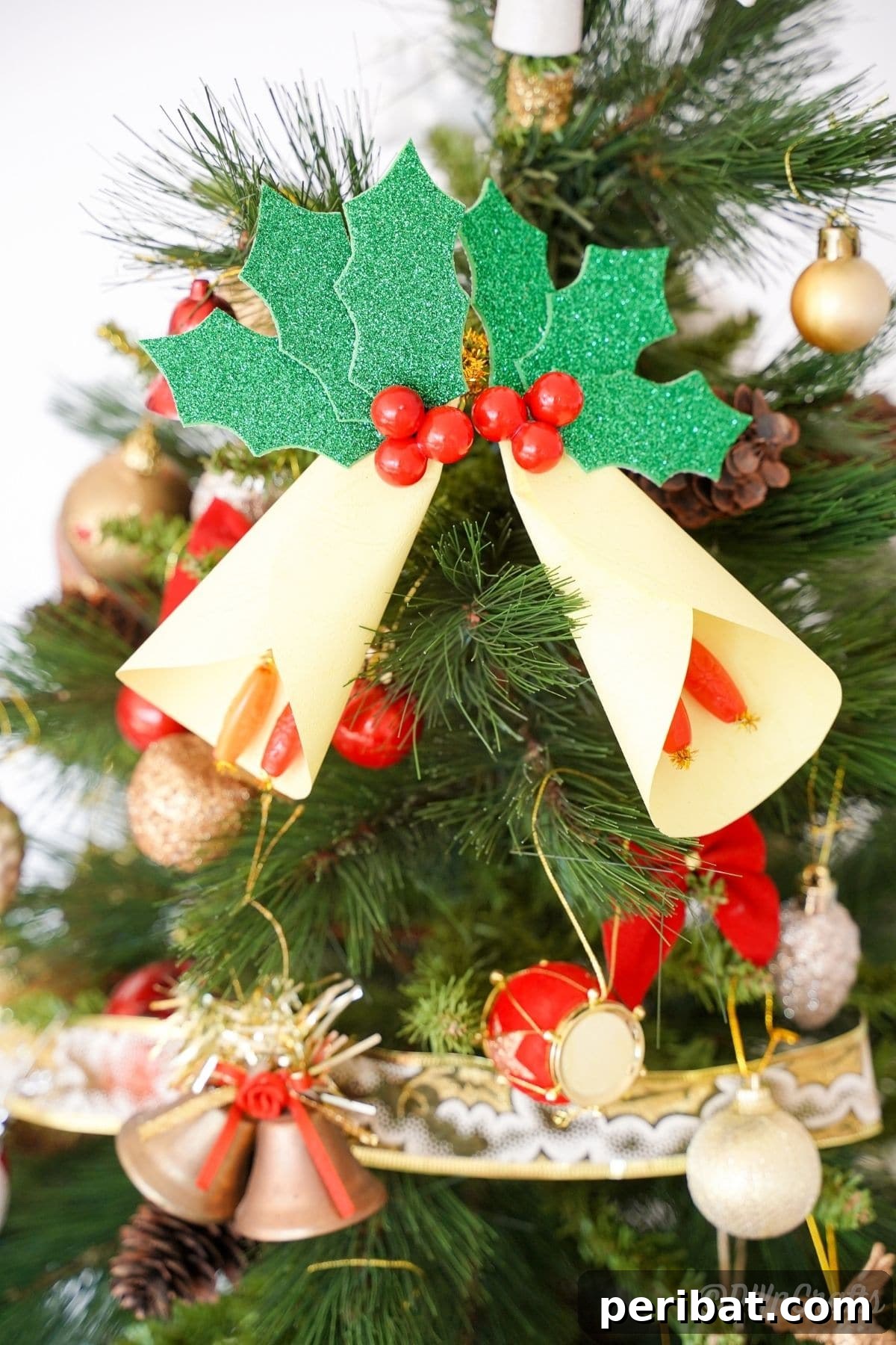 Handcrafted Paper Holly Christmas Ornament 2 paper bell ornaments on Christmas tree, showcasing vintage style and handmade appeal