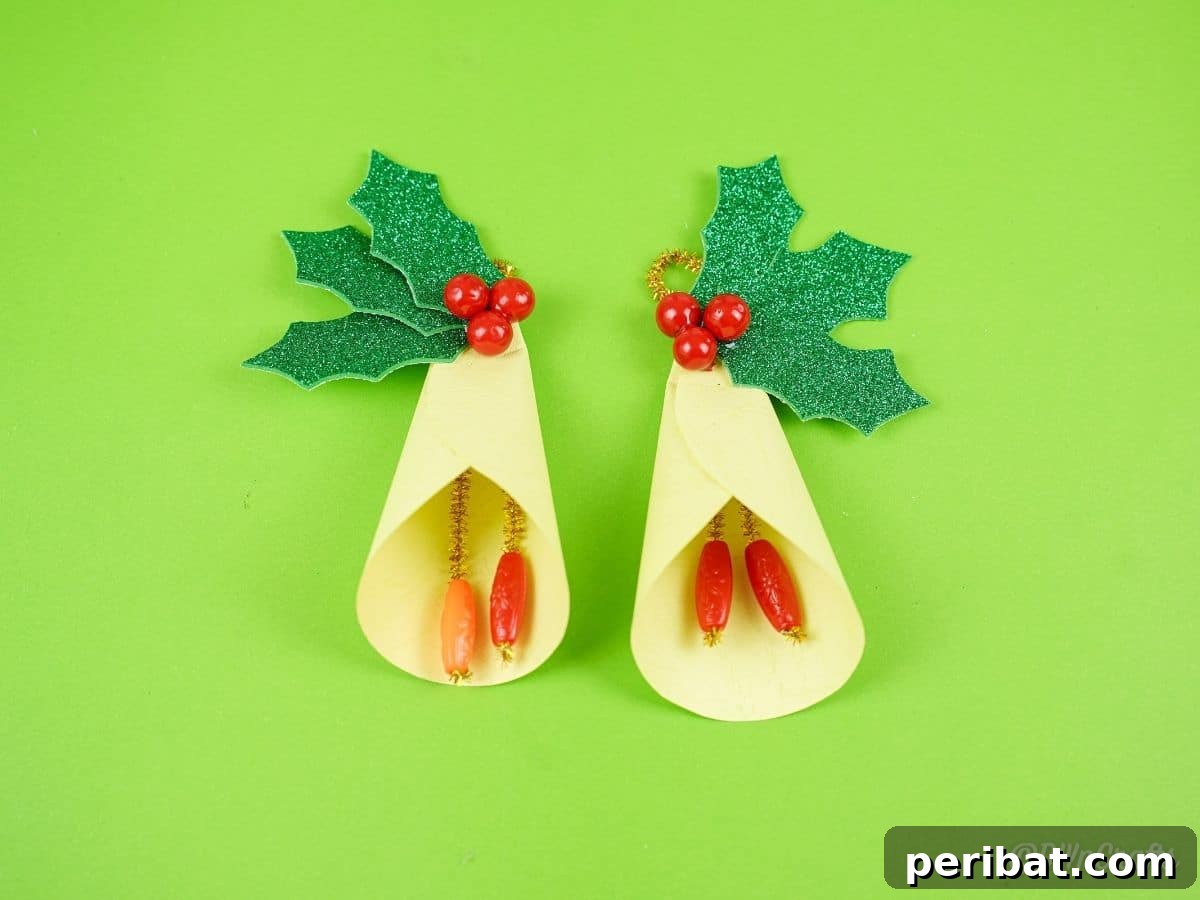 Handcrafted Paper Holly Christmas Ornament 8 two yellow bells with holly on green paper, showing completed ornaments
