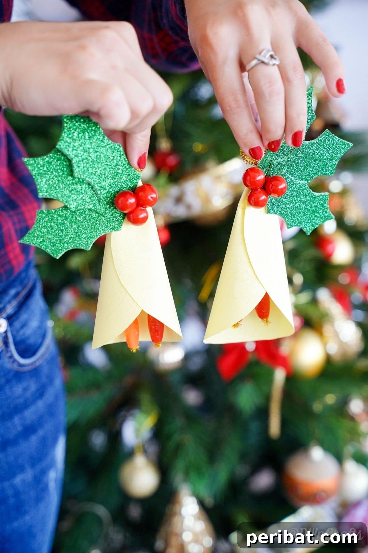 Handcrafted Paper Holly Christmas Ornament 9 ladies hands holding paper ornaments by Christmas tree, showing scale and placement