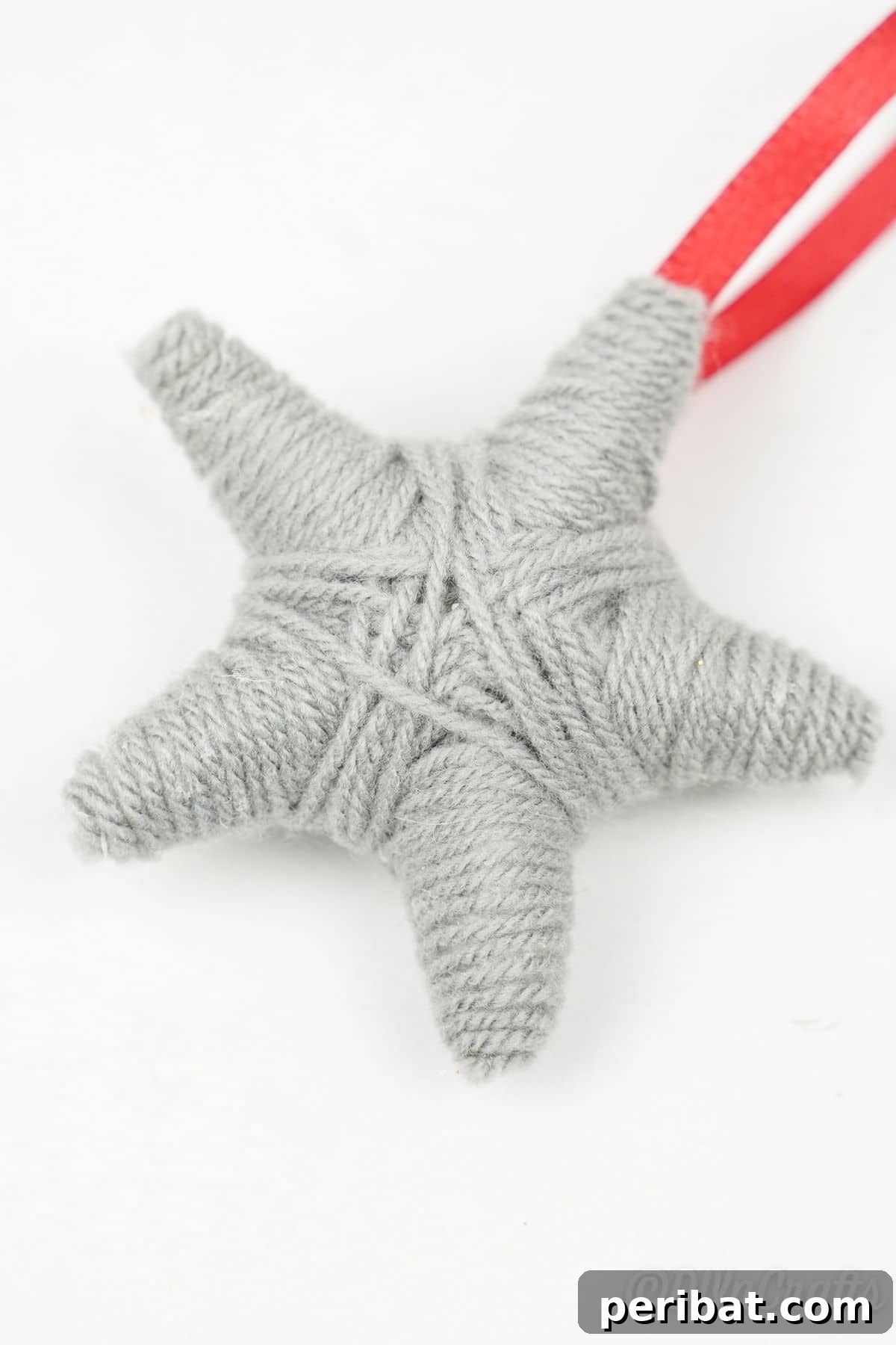 Charming Rustic Yarn Star Tree Ornament 14 gray star on white table