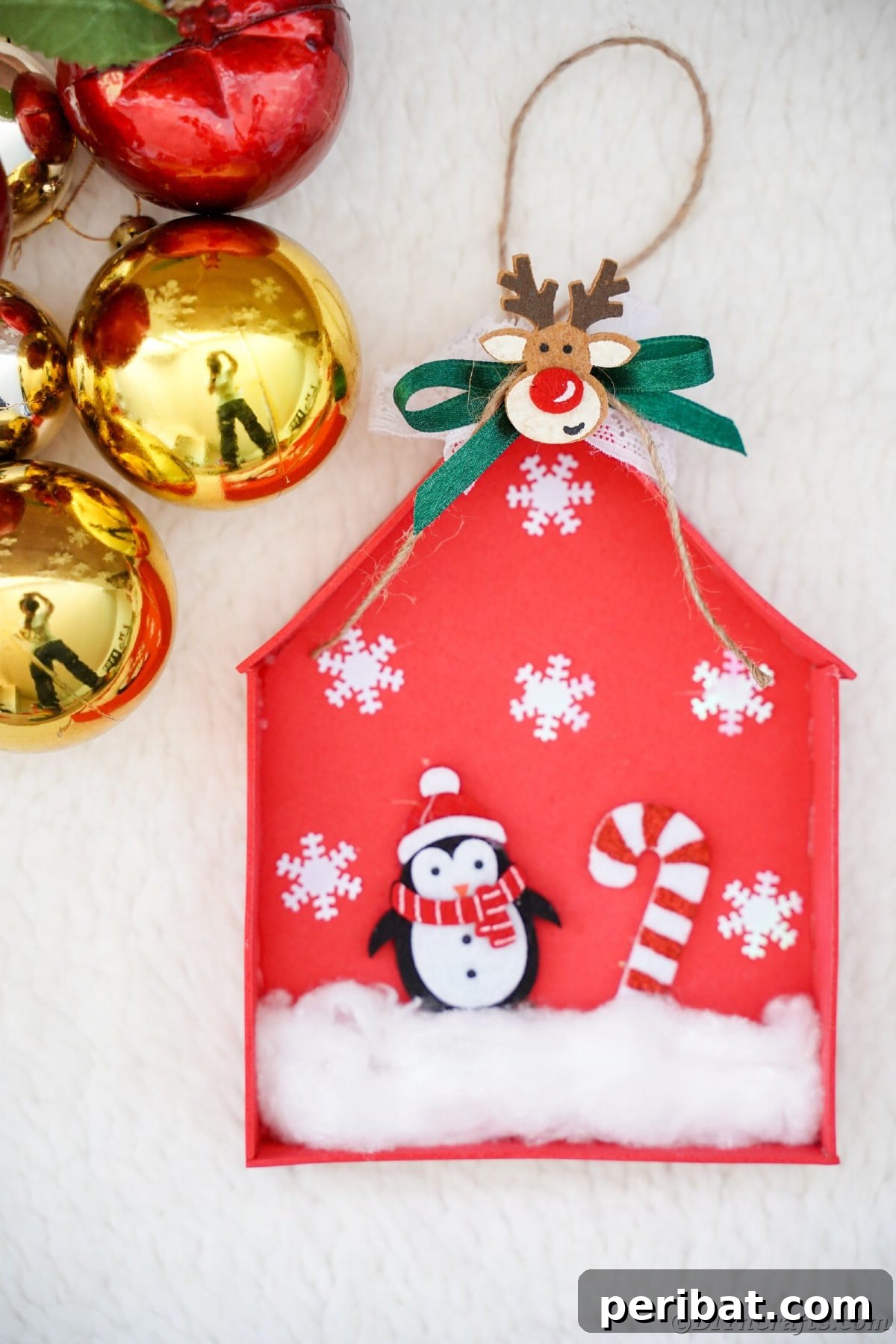 Whimsical Foam Penguin House Tree Ornament 4 Red and gold Christmas ornaments artfully arranged on a white table next to a finished red foam penguin house ornament