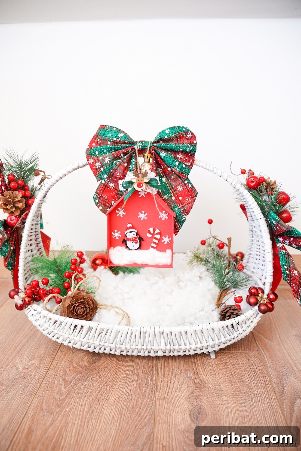 Whimsical Foam Penguin House Tree Ornament 6 A white decorative basket filled with fake snow and a red foam house ornament hanging elegantly beneath a green bow