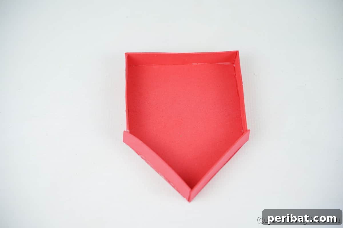 Whimsical Foam Penguin House Tree Ornament 10 A 3D red foam house with its framed edges visible, resting on a clean white table