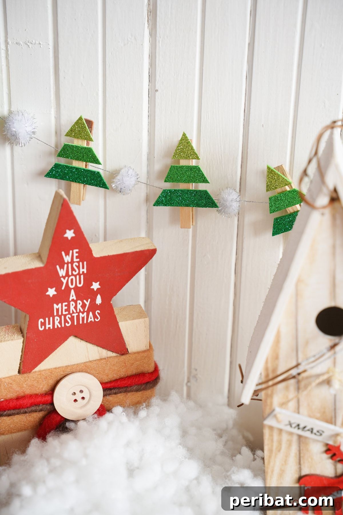 mini foam christmas tree on clothespins hanging on white shiplap behind holiday star decoration