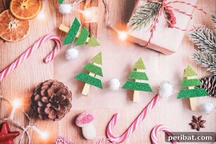 mini christmas tree garland laying by candy canes on holiday paper