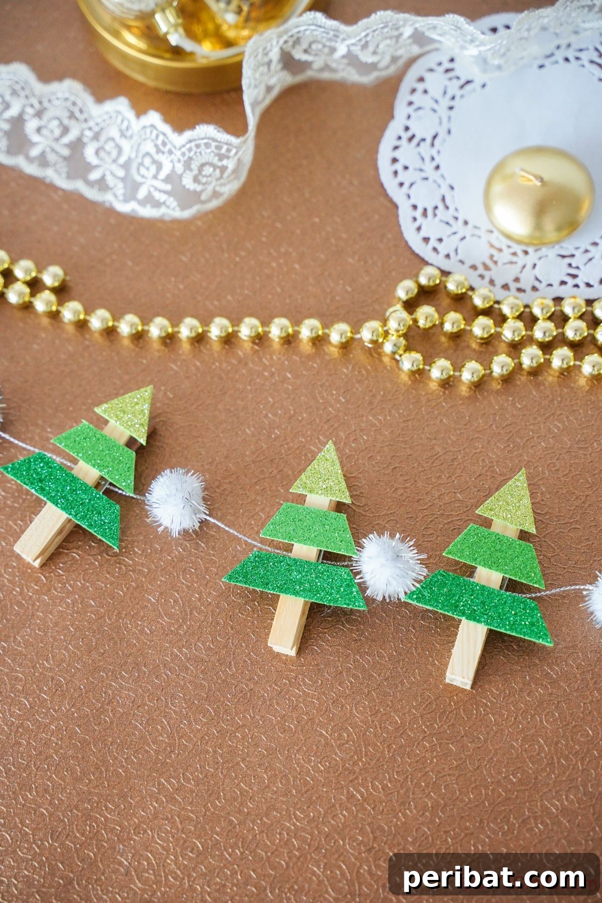 mini tree garland on brown table by lace and beads