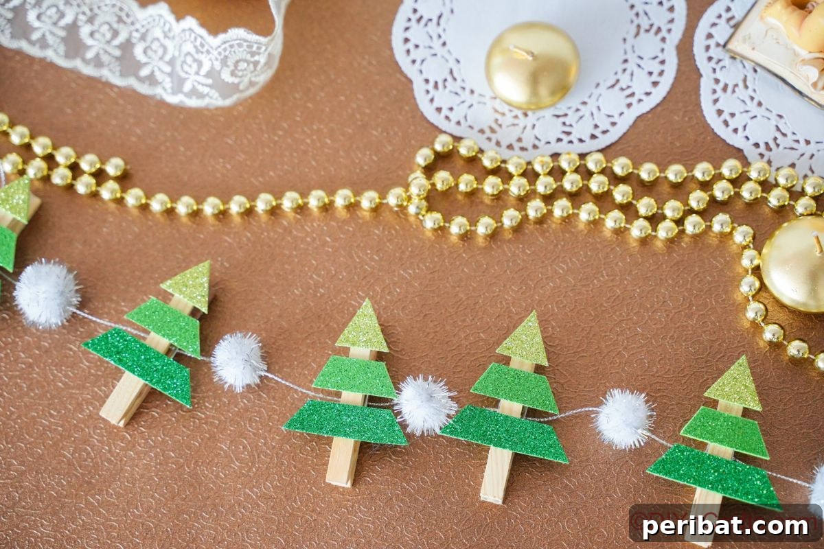 mini christmas tree garland laying on table by lace and gold string of beads