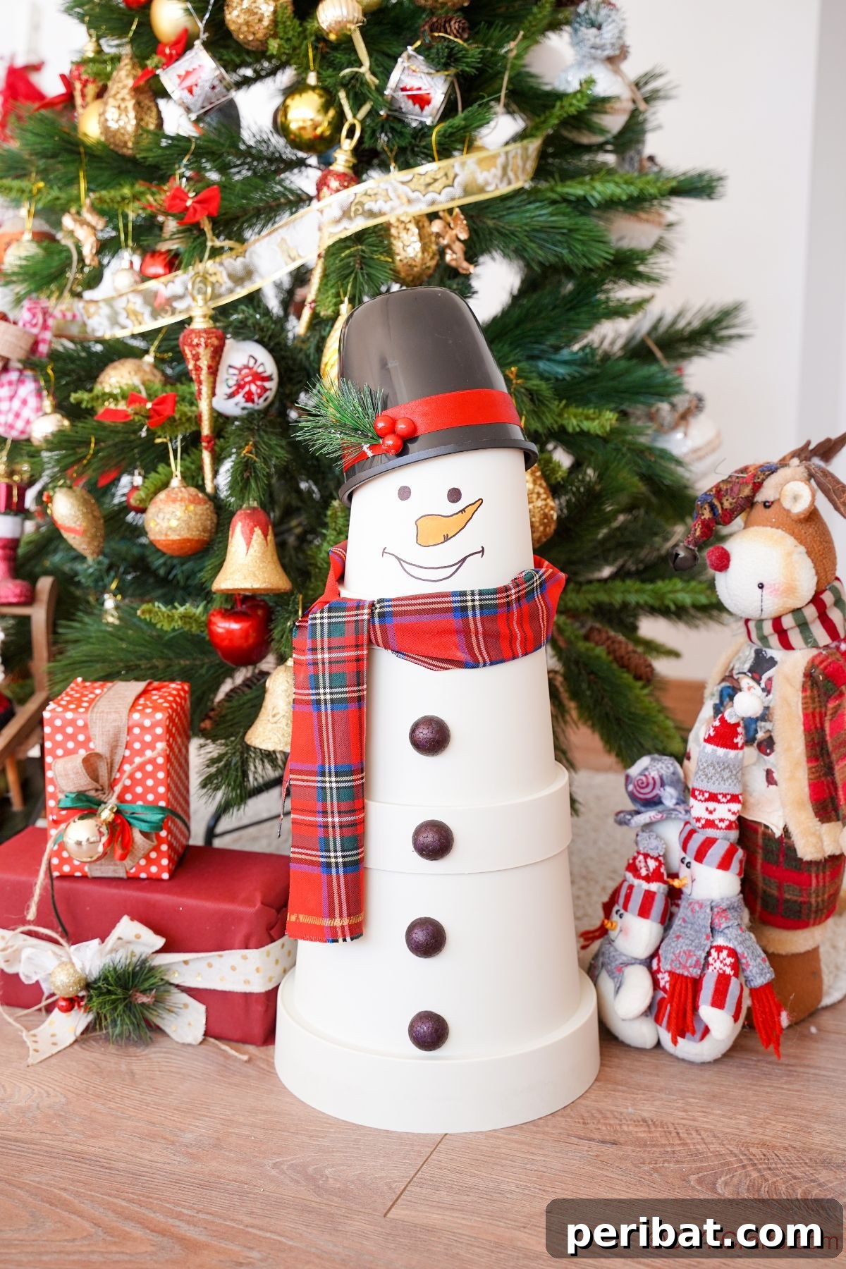 A festive flower pot snowman posing in front of a beautifully decorated Christmas tree adorned with gifts
