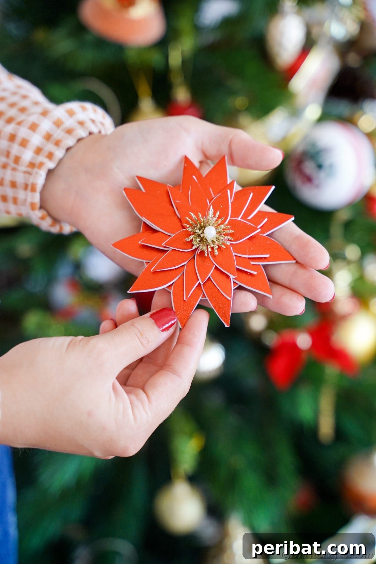 Craft Your Own Foam Poinsettia Brooch or Festive Ornament 12 Woman in front of Christmas tree holding a foam poinsettia
