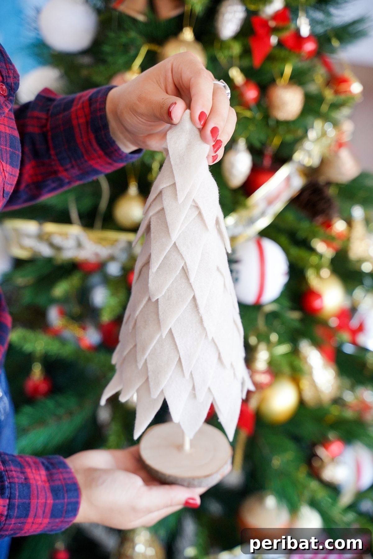 Cozy Upcycled Sweater Christmas Tree 15 cream fabric christmas tree being held in front of holiday tree with ornaments