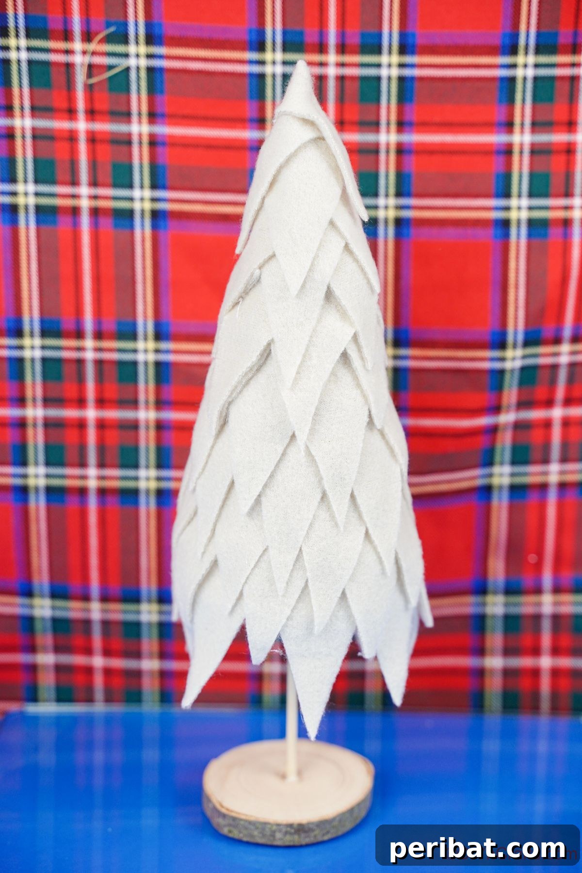 Cozy Upcycled Sweater Christmas Tree 17 cream fabric tree on blue table by plaid background