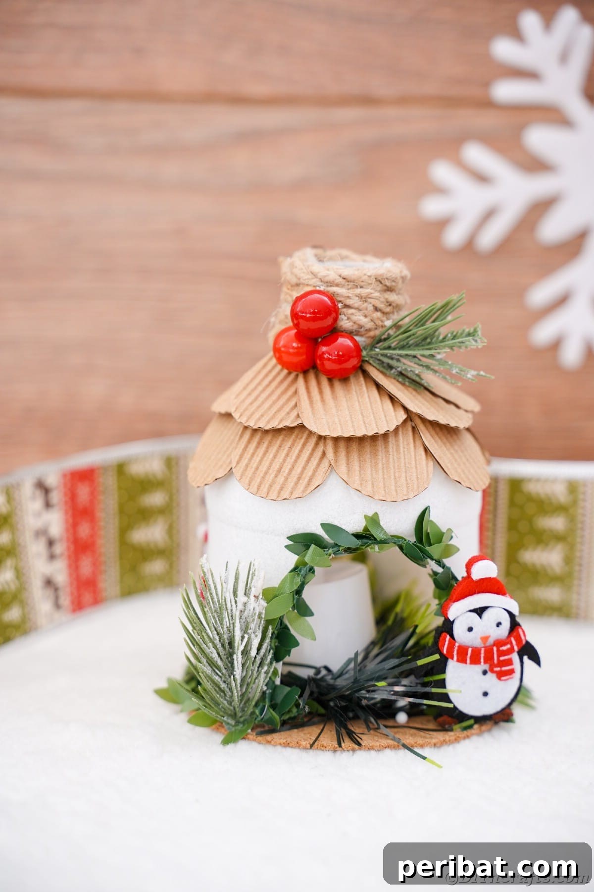 mini North Pole house made from plastic bottle sitting on white table with board background