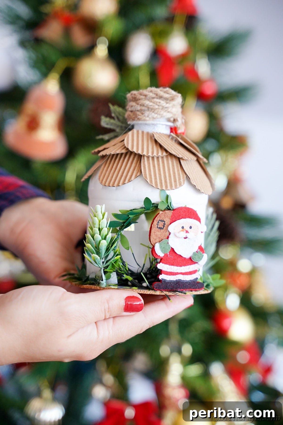 Ladies hand holding mini house with santa claus figurine on edge